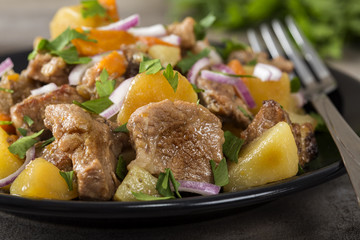 Baked potatoes, pork meat and carrots on plate