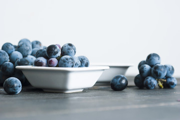 red grape juice in china bowl, black wood table background