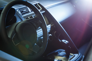 Dark luxury car Interior - steering wheel, shift lever and dashboard