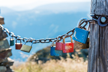 The metal locks hanging on a metal chain as a symbol of two people and their eternal love