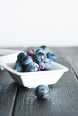 red grape juice in china bowl, black wood table background