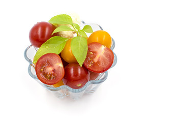 tomatoes, basil are in a glass bowl on a white background