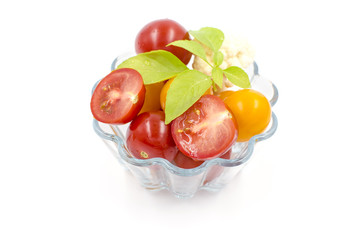 tomatoes, basil are in a glass bowl on a white background