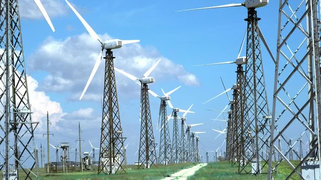 Old wind generators in a desert on a green grass, against a blue sky.