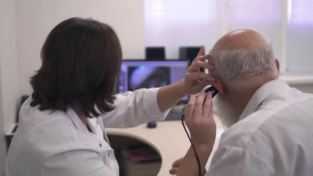 Medical professional tests the ear of an adult man