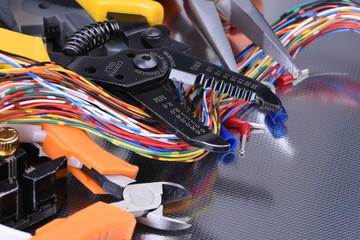Tools for electrician and cables on metal background