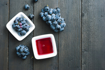 red grape juice in china bowl, black wood table background
