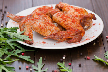 Baked chicken wings, on an old wooden background. Natural food cooked on the grill.