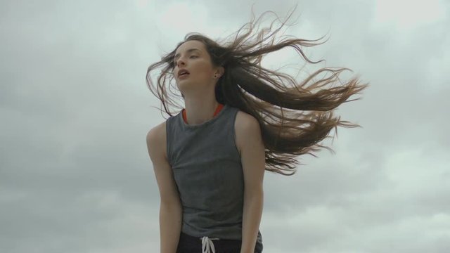 young female dancer with long hair performing hip hop moves in slowmotion. 