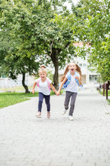 Obraz premium Funny children are running from school. The concept of school, study, education, friendship, childhood.