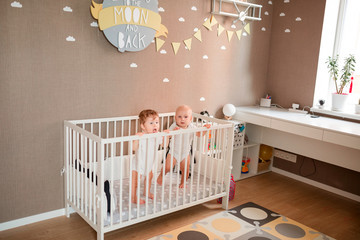 Cute little babies looking out of the bed