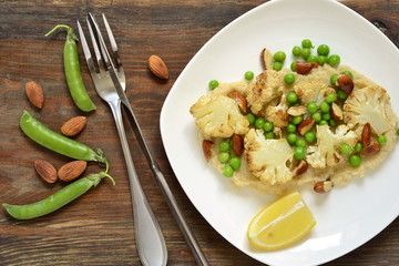 Salad with roasted cauliflower and green peas, almonds served on vegetable puree