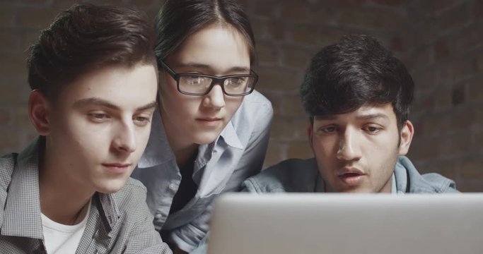 three students delighted or surprised with success of their project. teens descovering results of exams. education, friendship concept 4k