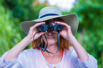a woman is smiling and watching through binoculars