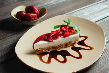 Slice of strawberry yogurt or coconut cake decorated with fresh fruits and mint on a plate. Delicious and sweet pink cake for Valentines or birthday party. Homemade bakery concept. Selective focus