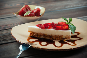 Slice of strawberry yogurt or coconut cake decorated with fresh fruits and mint on a plate. Delicious and sweet pink cake for Valentines or birthday party. Homemade bakery concept. Selective focus