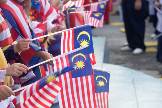 Hand waving Malaysia flag also known as Jalur Gemilang in conjunction with the Independence Day celebration or Merdeka Day.