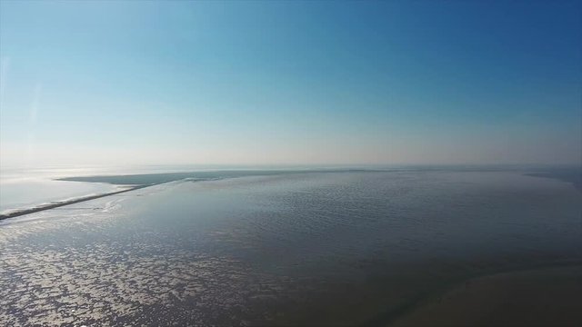 AERIAL: Hike to Halling Oland in the Wadden Sea on a sunny day