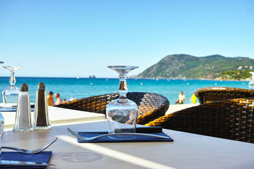 Elegant cafe with sea view on French Riviera is waiting for guests, served lunch table with...