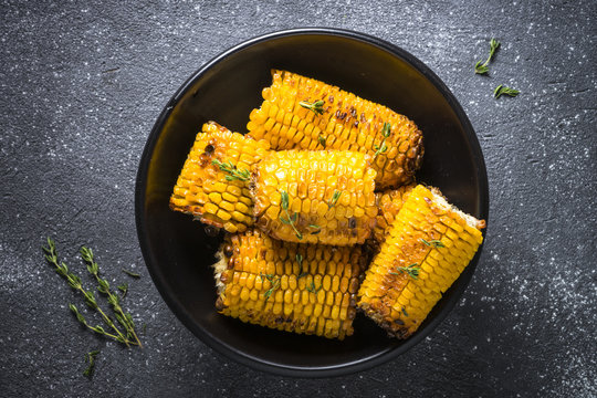 Grilled Corn With Spices Top View On Black.