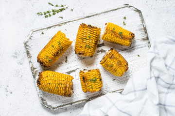 Grilled corn with spices top view on white.