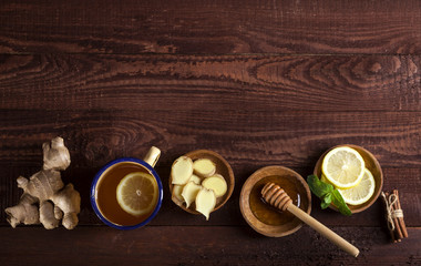 Ginger tea with lemon, mint and honey on wooden background