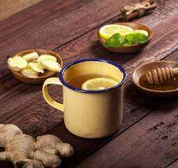 Ginger tea with lemon, mint and honey on wooden background