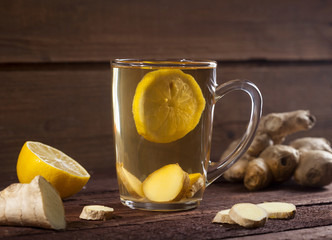 Ginger tea with lemon on wooden background