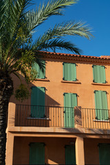 Fototapeta na wymiar Colors of Provence, France, summertime in small city on Mediterranean Sea, colorful facades and windows and palm trees