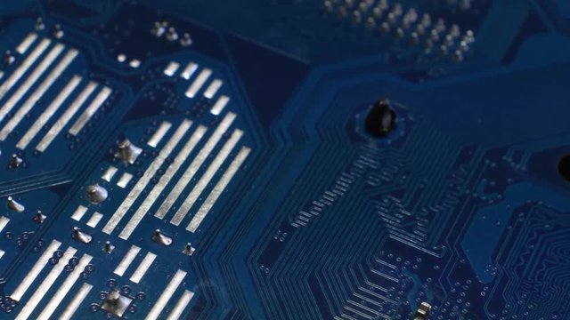 Closeup on blue electronic circuit board. Detail of pc motherboard.