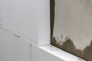 Close-up detail of plastered house wall with rigid styrofoam insulation. Modern technology,...