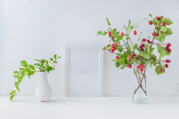 Mockup white frame and branches with red berries