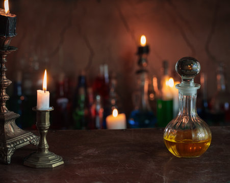 Magic potion, ancient books and candles on dark background