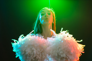 Blonde cheerleader woman posing with pom-poms at dancing studio