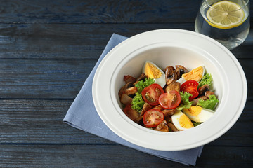 Plate with delicious fresh salad on table