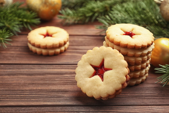 Traditional Christmas Linzer cookies with sweet jam on wooden table