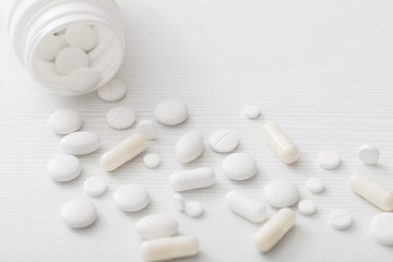 white pills on  white wooden background