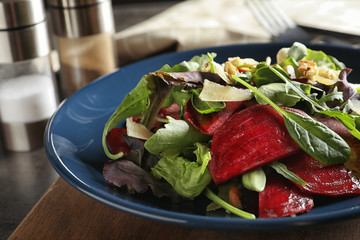Plate with delicious beet salad on wooden board, closeup