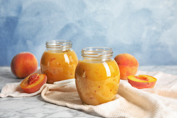 Tasty peach smoothie in glass jars on table