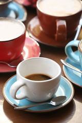 Cups of fresh aromatic coffee on wooden table