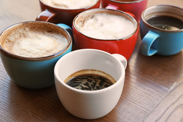Cups of fresh aromatic coffee on wooden table