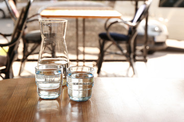 Glassware with water on wooden table indoors