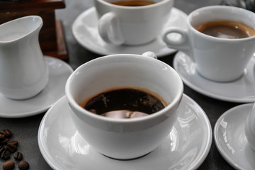 Cups of fresh aromatic coffee on grey background