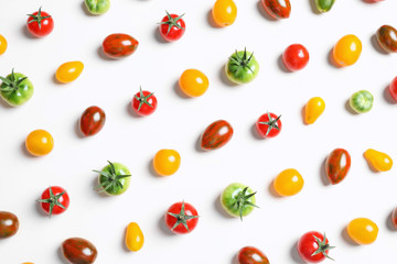 Flat lay composition with different tasty tomatoes on white background