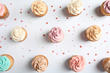 Flat lay composition with delicious birthday cupcakes on white background