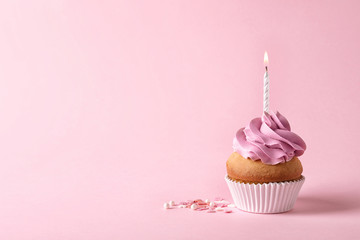 Delicious birthday cupcake with candle and space for text on color background