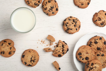 Flat lay composition with chocolate cookies and glass of milk on light background