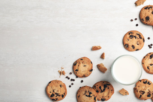 Flat lay composition with chocolate cookies and glass of milk on light background. Space for text