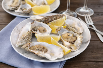 Fresh oysters with cut juicy lemon served on table