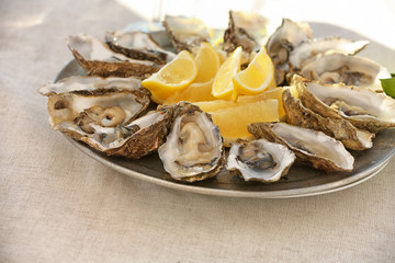 Fresh oysters with cut juicy lemon served on table